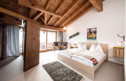 una camera con letto e soffitto in legno di Arena Penthouse a Flims