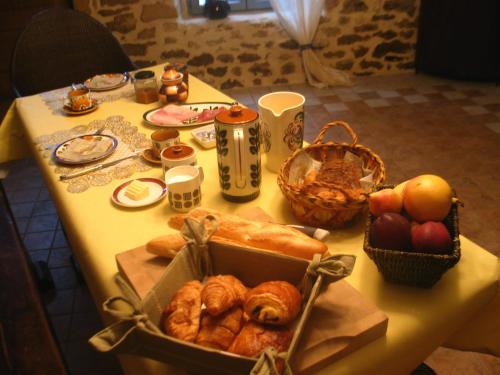a table with a box of pastries and baskets of bread at 4 Collines in Hagnicourt