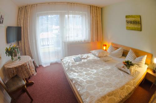 a bedroom with a large bed and a window at Europa Pension Tirol in Fliess