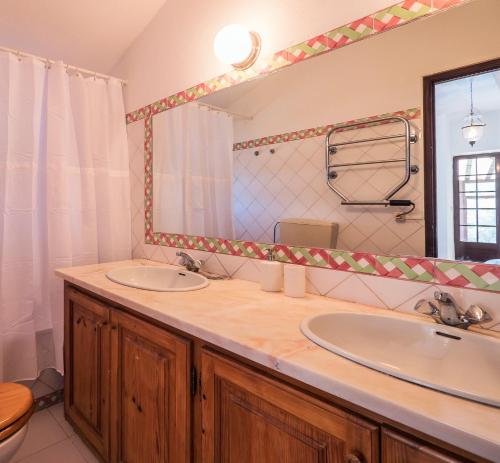 ein Badezimmer mit zwei Waschbecken und einem großen Spiegel in der Unterkunft Casa da Corredoura in Azoia