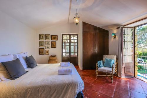 ein Schlafzimmer mit einem großen Bett und einem Stuhl in der Unterkunft Casa da Corredoura in Azoia