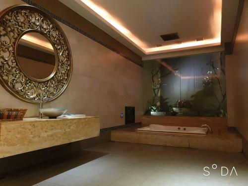 a bathroom with a tub and a large mirror at MUDU BREEZE MOTEL in Shulin