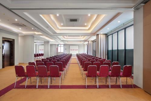 an empty room with red chairs in a room at favehotel Hasyim Ashari Tangerang in Tangerang