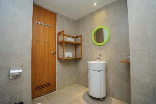 a bathroom with a toilet and a green mirror at Radja Art and Boutique Hotel Simpang Lima in Semarang