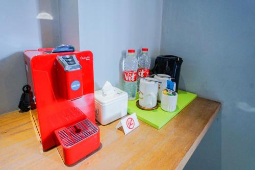 a red appliance sitting on top of a wooden table at Radja Art and Boutique Hotel Simpang Lima in Semarang