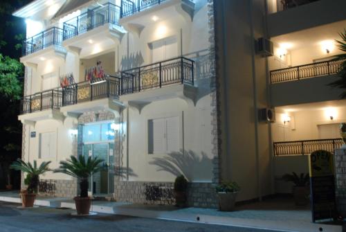 a white building with balconies and potted plants at 85 sqm Apartments New Panorama ELECTRIC CAR ΦΩΡΤΗΣΗΣ STATION in Paralion astros
