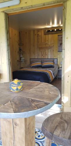 a bedroom with a bed and a table and a bed at LA CABANE PERCHEE in Villelaure