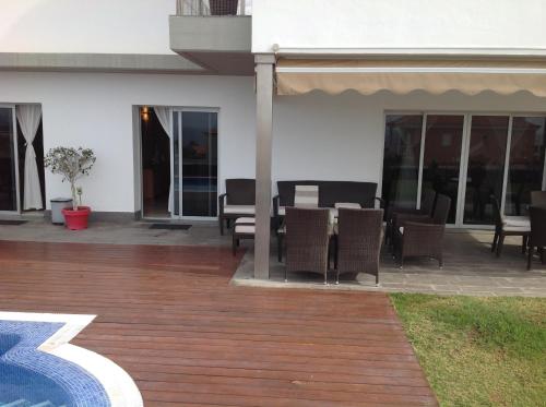 a patio with a table and chairs and a building at Petit Paradis - A little bit of heaven in Callao Salvaje