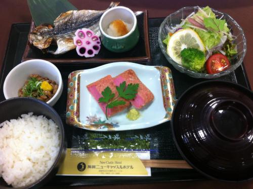 Hamada New Castle Hotel في Hamada: صينية طعام مع رز وسمك وخضروات