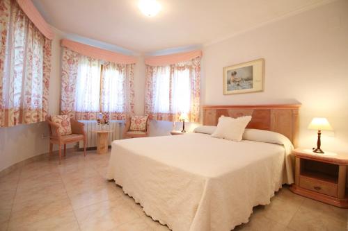 a bedroom with a bed and a table and windows at Els Poblets ER by CARLOSFERIEN in El Verger