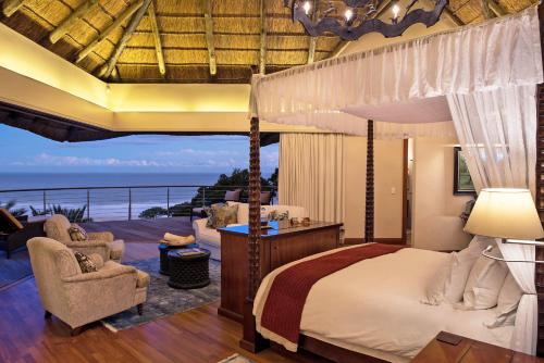 a bedroom with a canopy bed with a view of the ocean at Oceana Beach and Wildlife Reserve in Port Alfred
