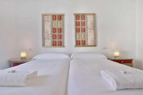 2 weiße Betten in einem Zimmer mit 2 Fenstern in der Unterkunft Casa del Portillo-Centro Histórico in Córdoba