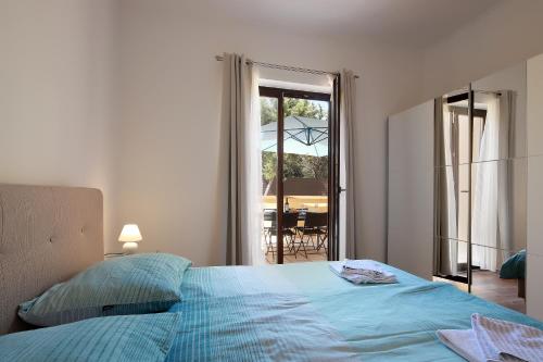 a bedroom with a bed and a view of a patio at Apartments Galboka in Nerezine