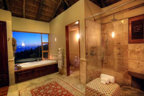 La grande salle de bains est pourvue d'une baignoire et d'une douche. dans l'établissement Oceana Beach and Wildlife Reserve, à Port Alfred