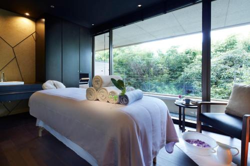 a bedroom with a bed and a large window at Hilltop Resort Fukuoka in Fukuoka