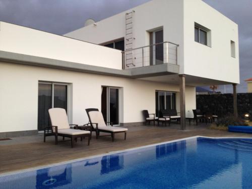 a villa with a swimming pool and a house at Petit Paradis - A little bit of heaven in Callao Salvaje