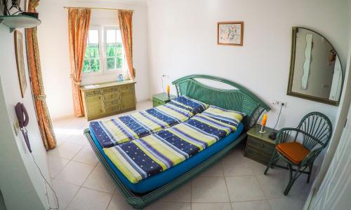 a bedroom with a bed and a chair and a window at Pensión Los Caballos in Els Poblets