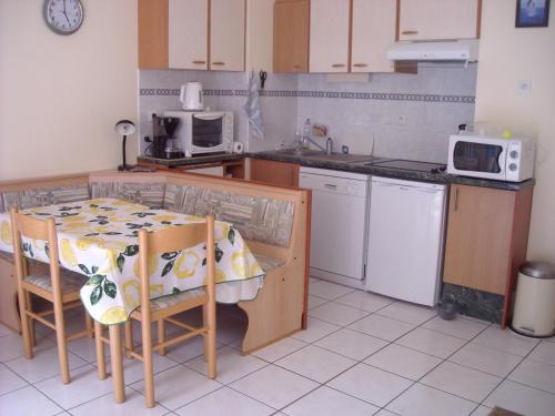 une petite cuisine avec une table et un micro-ondes dans l'établissement Location à la semaine Paradis de Saint Cast, à Saint-Cast-le-Guildo