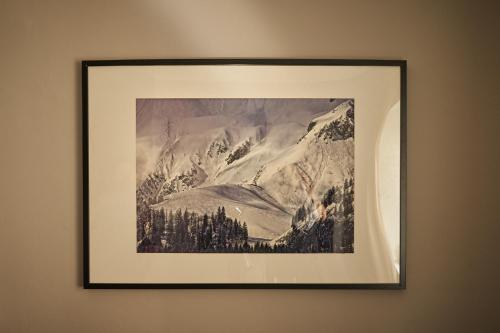 a framed picture of a mountain on a wall at KitzHome City Apartments in Kitzbühel