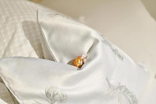 a gold object sitting in the pocket of a white blanket at KitzHome City Apartments in Kitzbühel