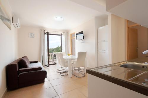 a kitchen and living room with a couch and a table at Apartments Galboka in Nerezine