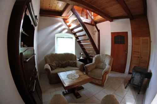 a living room with chairs and a table and stairs at Pałac Heymanna - Stara Kuchnia in Ścibórz