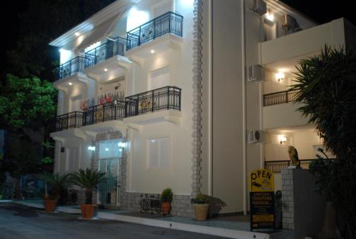 a white apartment building with a balcony at night at 85 sqm Apartments New Panorama ELECTRIC CAR ΦΩΡΤΗΣΗΣ STATION in Paralion astros