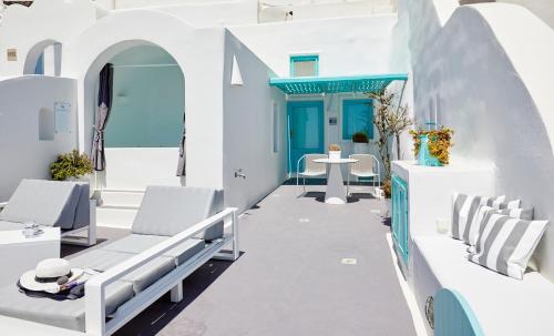 a porch with a blue door and chairs at Dreams Luxury Suites in Imerovigli