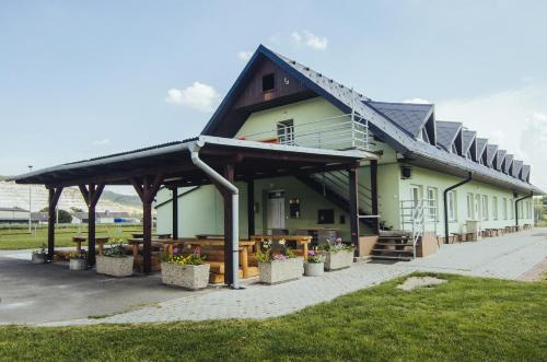 a building with a porch and tables and benches at Guest House Na Hřišti in Leština