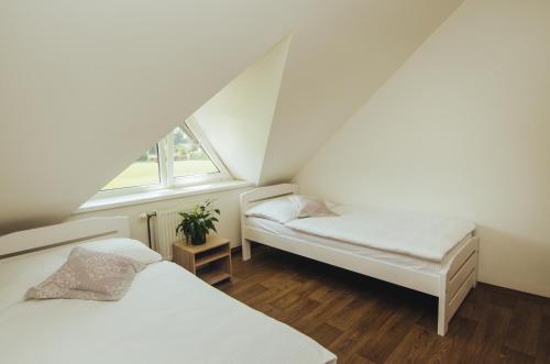 a attic bedroom with two beds and a window at Guest House Na Hřišti in Leština