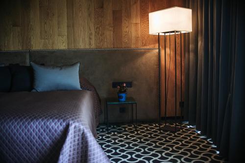 a bedroom with a bed and a lamp and a table at Lajvér Borbirtok in Szálka