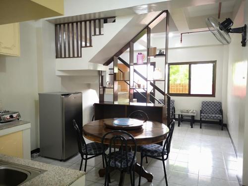 cocina y comedor con mesa y sillas en JDL Residences Hostel, en Legazpi