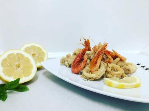 a plate of food with shrimp and lemon slices at Hotel Rodà in Panarea