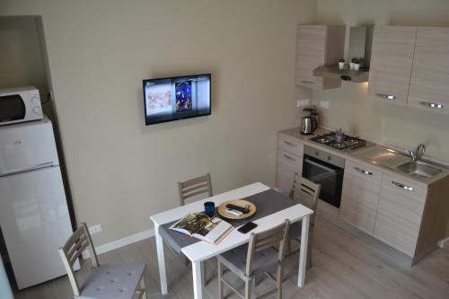 a small kitchen with a table and chairs and a refrigerator at DOMUS LINGOTTO in Turin