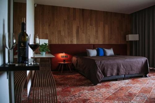 a bedroom with a bed and a table with a bottle of wine at Lajvér Borbirtok in Szálka