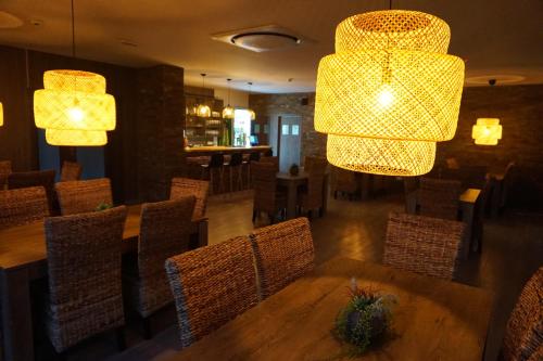 a restaurant with a table and chairs and chandeliers at Pensiunea Patru Anotimpuri in Sasca Română