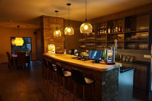 a bar in a restaurant with a counter and chairs at Pensiunea Patru Anotimpuri in Sasca Română