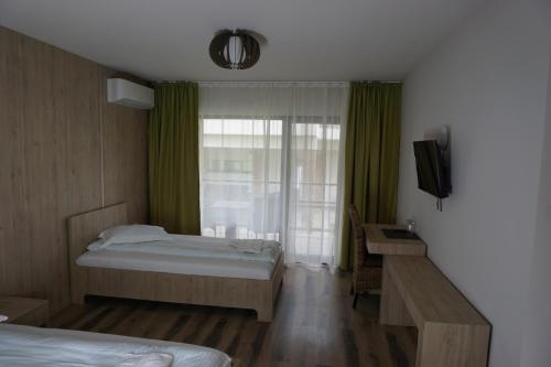 a hotel room with two beds and a window at Pensiunea Patru Anotimpuri in Sasca Română