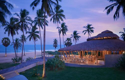 a resort with a gazebo on the beach at night at Jetwing Surf & Safari, A Luxury Reserve in Arugam Bay