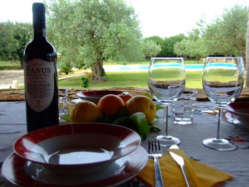 a table with a bottle of wine and two glasses at Agriturismo Masseria Sant' Elia in Arenella