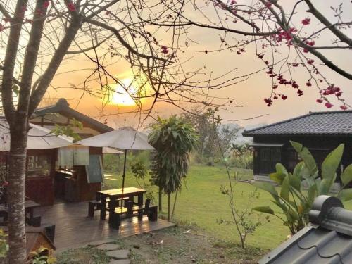 a patio with a table and an umbrella in front of a house at Sun Moon Home in Yuchi