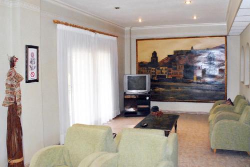 sala de estar con sofá y TV en Hostal Rey Teodomiro, en Orihuela