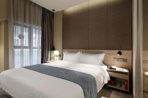 Un pat sau paturi într-o cameră la Hanyong Hotel -Shenzhen International Convention&Exhibition Fuyong Branch