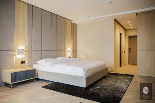 ein Schlafzimmer mit einem großen weißen Bett in einem Zimmer in der Unterkunft VisPas Hotel in Chişinău