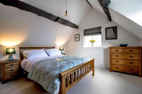 a bedroom with a bed and a dresser and a window at Little George in Henley in Arden
