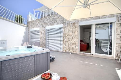 a large bathroom with a hot tub and an umbrella at Jacuzzi Holiday Homes by LoveSud in Leuca