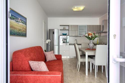 a living room with a red couch and a table at Jacuzzi Holiday Homes by LoveSud in Leuca