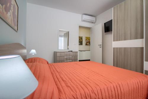 a bedroom with a orange bed in a room at Jacuzzi Holiday Homes by LoveSud in Leuca