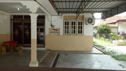 an outside view of a building with a gate at Syahril homestay in Dungun