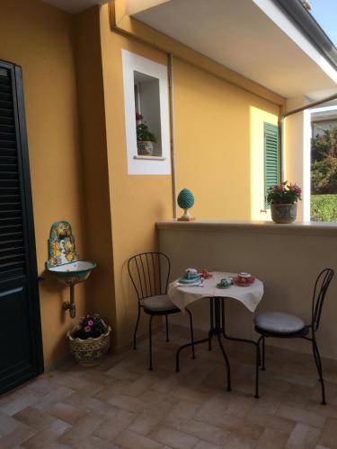 a patio with two chairs and a table and two windows at BeB L'ALLORO in Pachino
